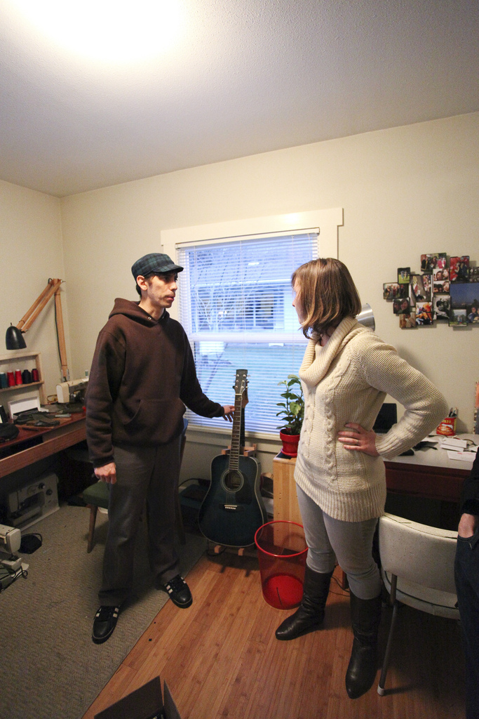 Santi with his guitar beside a visitor in the living room