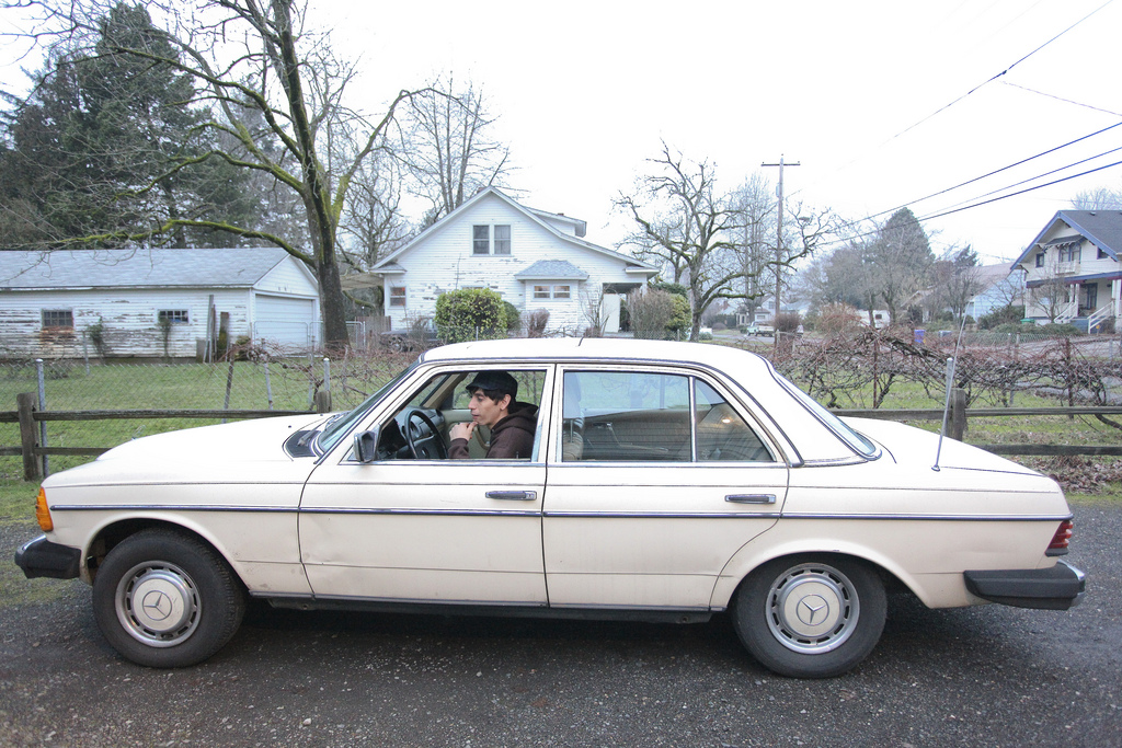 Santi at the wheel of the cream-colored Mercedes sedan