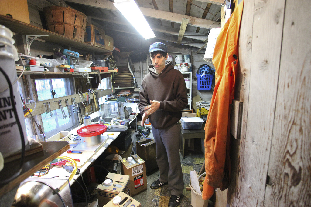 Santi standing in his cluttered workshop